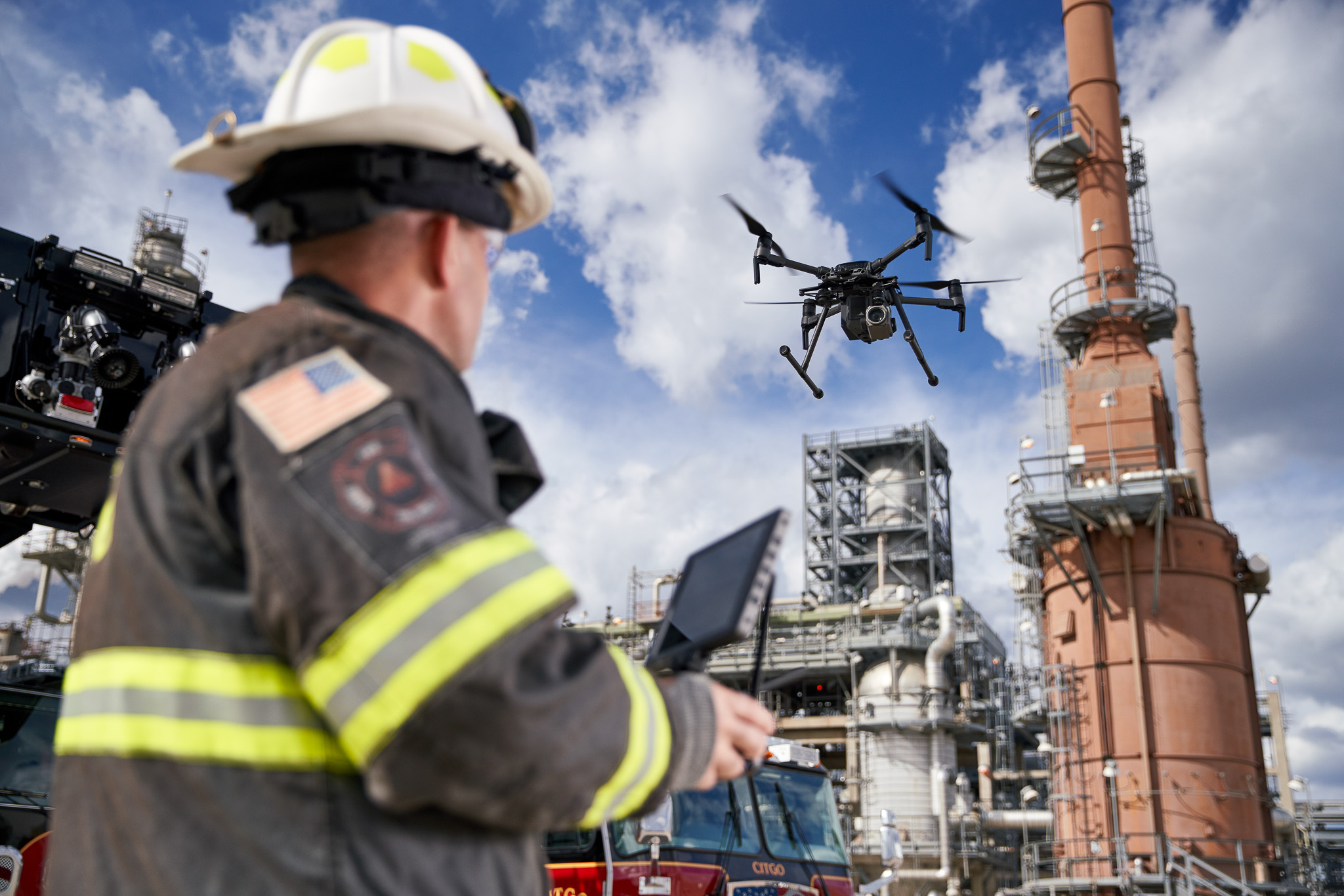 A firefighter inspecting with a drone in an oil refinery for an industrial photography shoot.
